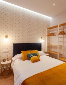马德里MIMA Suites Chueca的卧室配有一张带黄色枕头的大型白色床。