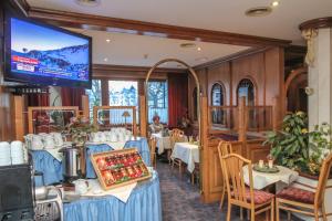 瓦德林Hotel Tiroler Adler Bed & Breakfast的餐厅设有桌子和平面电视。