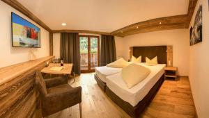 考恩台尔Hotel Edelweiss Superior的配有一张床和一张书桌的酒店客房