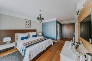 斯塔拉巴斯卡Eola Leisure Rooms的一间卧室配有一张大床和蓝色床头板