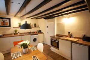 诺里奇No 88 UPPER ST GILES - Elegant, Stylish Townhouse的带木桌的厨房和带水槽的厨房