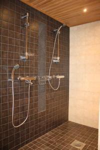 萨利色尔卡卡斯蒂略别墅的浴室铺有棕色瓷砖,设有淋浴。