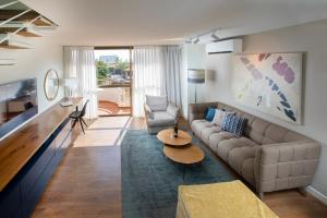 荷兹利亚海洋高地套房公寓式酒店的客厅配有沙发和桌子