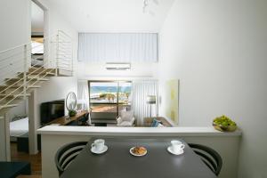 荷兹利亚海洋高地套房公寓式酒店的厨房以及带餐桌的起居室。