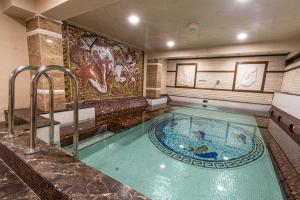 希典Sunny Paradise ll - Daniela Wellness and SPA的一座大型游泳池,位于酒店客房内,设有浴缸