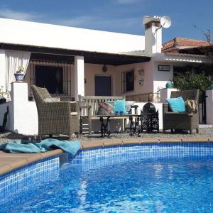 阿洛拉Casa al Cerro的房屋旁的游泳池配有桌椅