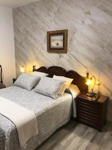 法塔加La Socorra Suite Adults Only的一间卧室配有一张床和一张带台灯的桌子