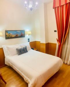 罗马加西亚酒店的卧室配有白色的床和红色窗帘
