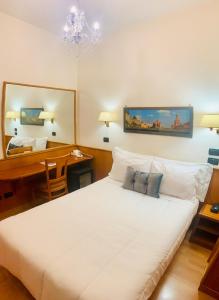 罗马加西亚酒店的卧室配有一张白色大床和一张书桌