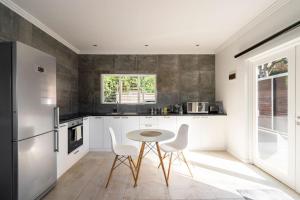 德班Casa Casa - Studio的厨房配有白色橱柜和桌椅