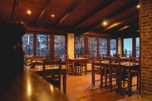 斯图帕瓦Il Galeone hotel的餐厅设有木桌、椅子和窗户。