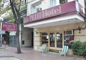 门多萨Hotel Petit的大楼前有两把椅子的酒店