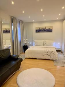 贝林佐拉Casa Nataliya, via tampori 8 6503 Bellinzona的卧室配有白色的床和沙发