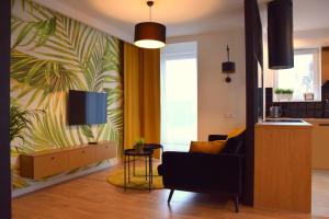 科沙林W&K Apartments - Gold Suite的客厅配有沙发和墙上的电视