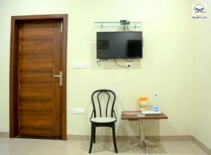 马图拉HOTEL BABYLON REGENCY, Opp Krishna Janmabhoomi Temple的椅子和桌子,墙上有电视