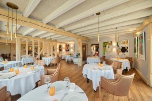 梅斯尼圣佩尔Logis Maison Gublin - Auberge du Lac的一间设有白色桌椅的用餐室