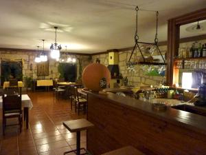Outeiro奥菲西纳乔宾馆的餐厅内的酒吧配有桌椅