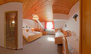 特翁特维格霍夫酒店的一间卧室设有两张床和大型木制天花板