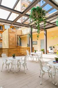 罗马艾特尔诺环保旅馆的庭院设有白色的桌椅和玻璃天花板。