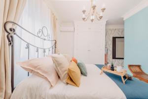 马拉加South Nature Rooms的卧室配有带枕头和吊灯的白色床。