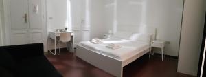 卡利亚里卡利亚里达玛雷维亚罗马酒店的白色的卧室配有白色的床和一张桌子