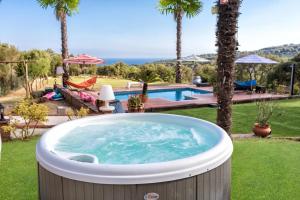 阿雷尼斯-德蒙特Villa Costa Barcelona的游泳池旁的庭院里的一个热水浴池