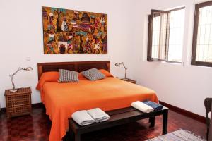 明德卢Vila Mira Mar的一间卧室配有一张带橙色毯子的床