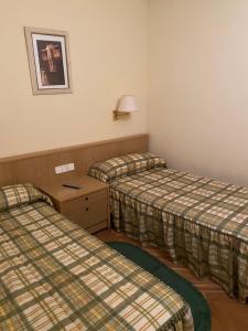 BustarviejoMirasierra的酒店客房设有两张床和一张桌子。