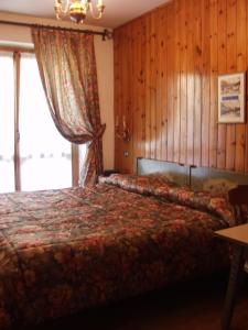 摩德纳迪-坎皮格里奥圣胡贝图斯加尼酒店的一间卧室设有一张床和一个大窗户
