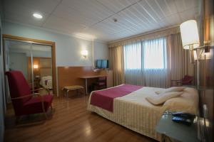 阿尔科伊卢克索雷孔基斯塔酒店的酒店客房,配有一张床、一张桌子和椅子