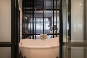 清迈Iron32 Hotel的带浴缸的浴室和窗户