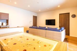 北谷町LAPIN MIHAMA Residence Hotel的客厅配有蓝色的沙发和平面电视。
