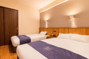 北谷町LAPIN MIHAMA Residence Hotel的一间酒店客房,房间内设有两张床