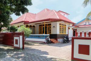 巴东Wisma Mutiara的一座红色屋顶和门的房子