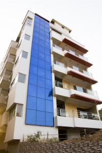 古瓦哈提Hotel Park Riviera的一栋高高的公寓楼,设有蓝色的玻璃窗