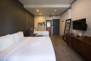清迈Iron32 Hotel的酒店客房设有两张床和一台平面电视。