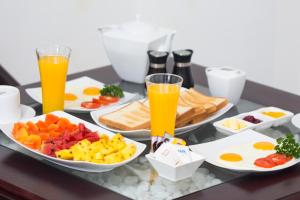 维勒珀图Cloud Nine Wilpattu by Aaradhya的包括橙汁和鸡蛋的早餐食品托盘