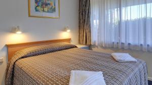 莫韦尔Cedar Lodge Motel的一间卧室配有一张床,上面有两条毛巾