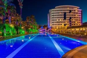 安塔利亚拜尔罗港水疗度假酒店的一座游泳池,在晚上在建筑物前