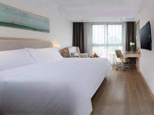 澄迈维也纳3好酒店 (海口澄迈老城店)的酒店客房设有一张白色大床和一张书桌