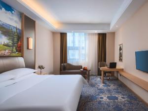 金山区维也纳酒店(上海金山卫火车站城市沙滩店)的酒店客房设有一张大床和一张书桌。