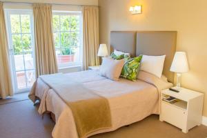 普利登堡湾米尔克伍德庄园大海酒店的一间卧室设有一张大床和两个窗户