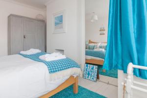 布罗德斯泰Sea Glimpses with garden, beachhut, parking的一间卧室配有两张床和蓝色窗帘