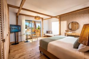 赫索尼索斯斯特拉岛豪华度假酒店（仅限成人）的酒店客房,配有床和电视