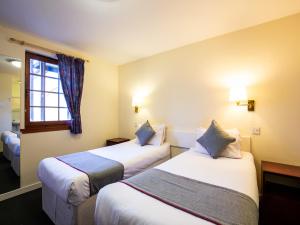邓迪隆佛甘客栈的酒店客房设有两张床和窗户。