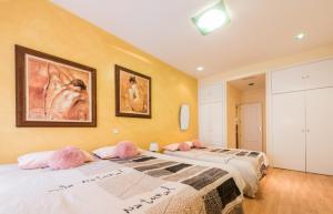 马德里M&F FUENCARRAL的一间卧室配有两张带粉红色枕头的床