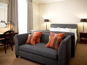 阿伯加文尼天使酒店的客厅配有蓝色长沙发及橙色枕头