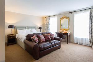 阿伯加文尼天使酒店的一间卧室配有一张床、一张沙发和一面镜子