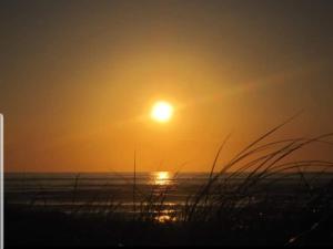 斯莱戈Surfers Getaway - Room Staycation的海滩上的日落与海洋和草地