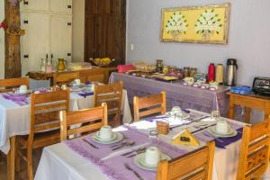 蒂拉登特斯Casa de Violeta Pousada的用餐室配有桌椅和紫色桌布